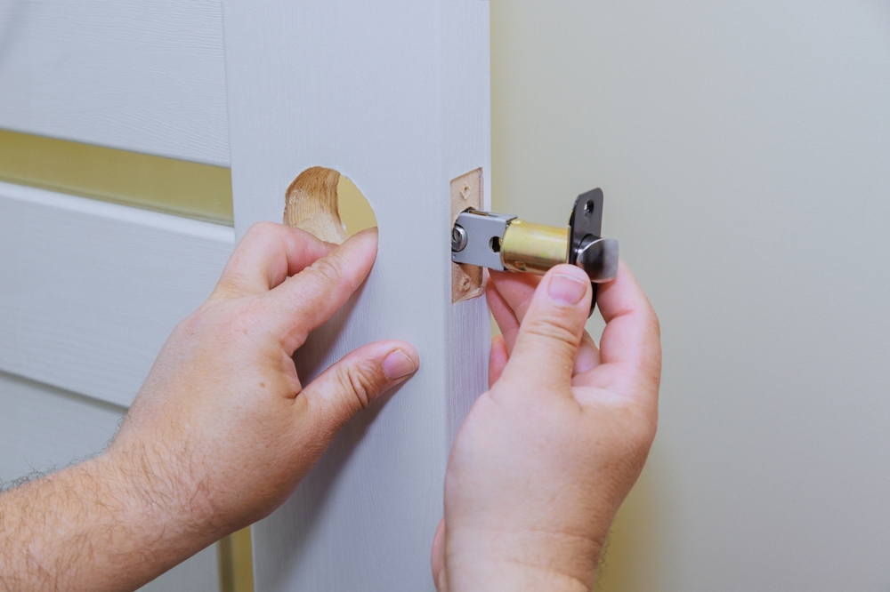 Locksmith demonstrating a secure lock mechanism on a front door with a thumbs up