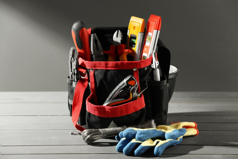 A locksmith's toolkit with various tools and keys laid out on a workbench.