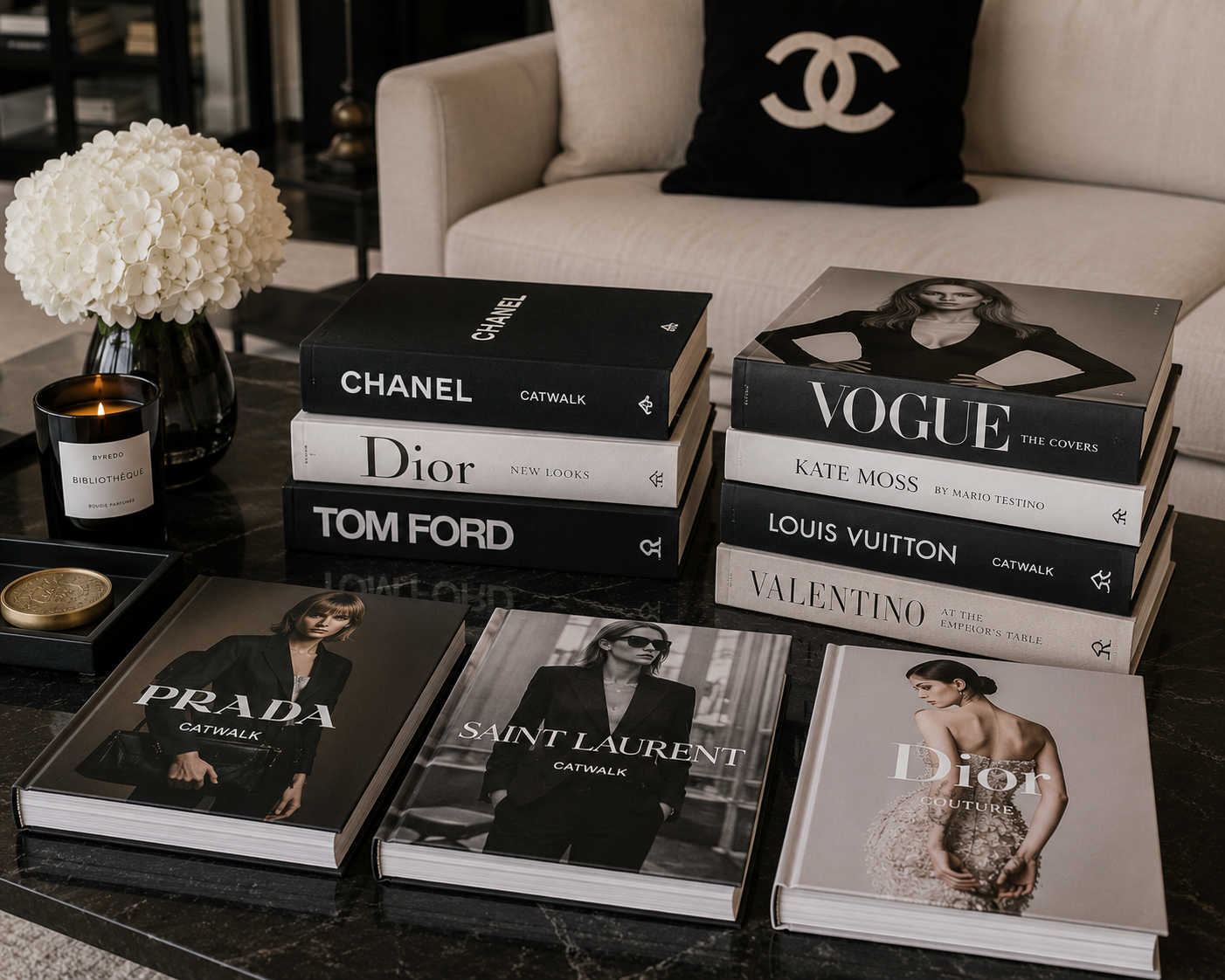 A collection of fashionable coffee table books featuring glossy covers on high-end fashion, neatly arranged on a sleek table.